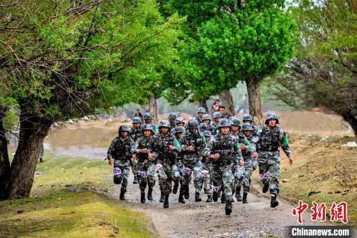 图为5公里武装越野赛参赛官兵路过砂石路段。 路建 摄