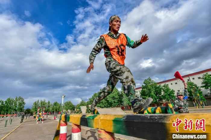 在400米障碍跑比赛项目中，一名战士正在飞跃独木桥。 蒲津 摄