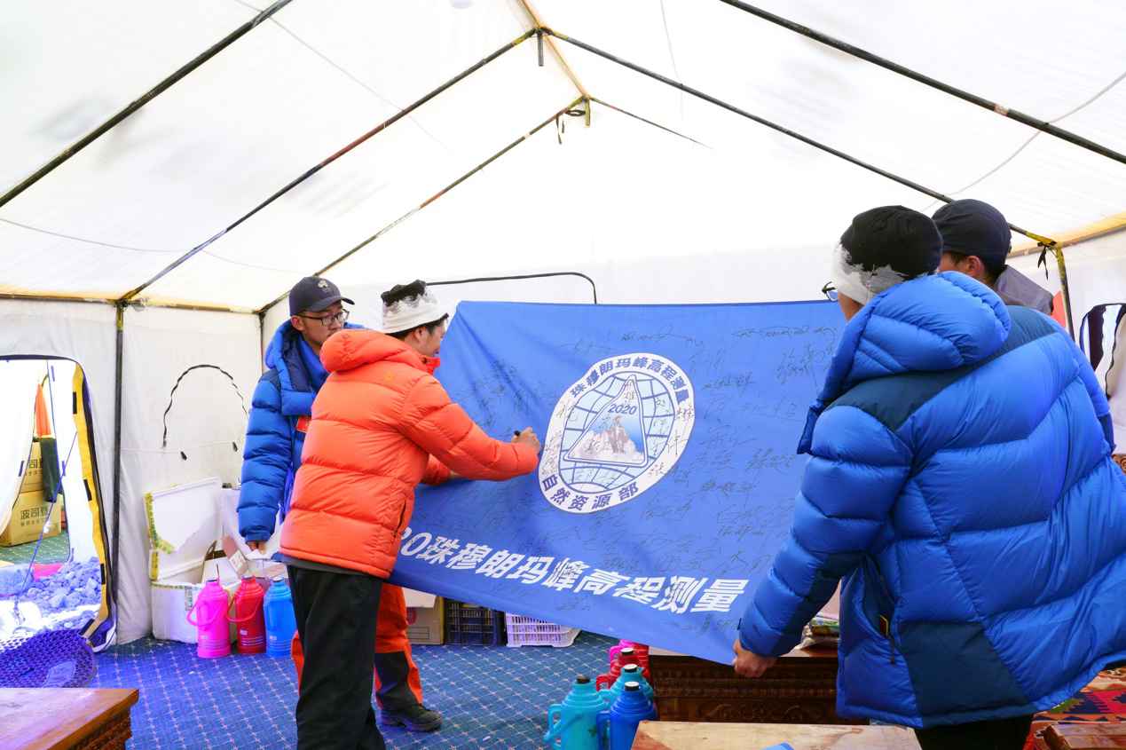 队员们在本次活动旗帜上签名留念。中国登山协会供图 卢明文摄 2020珠峰测量登山队召开冲顶动员大会 预计22日登
